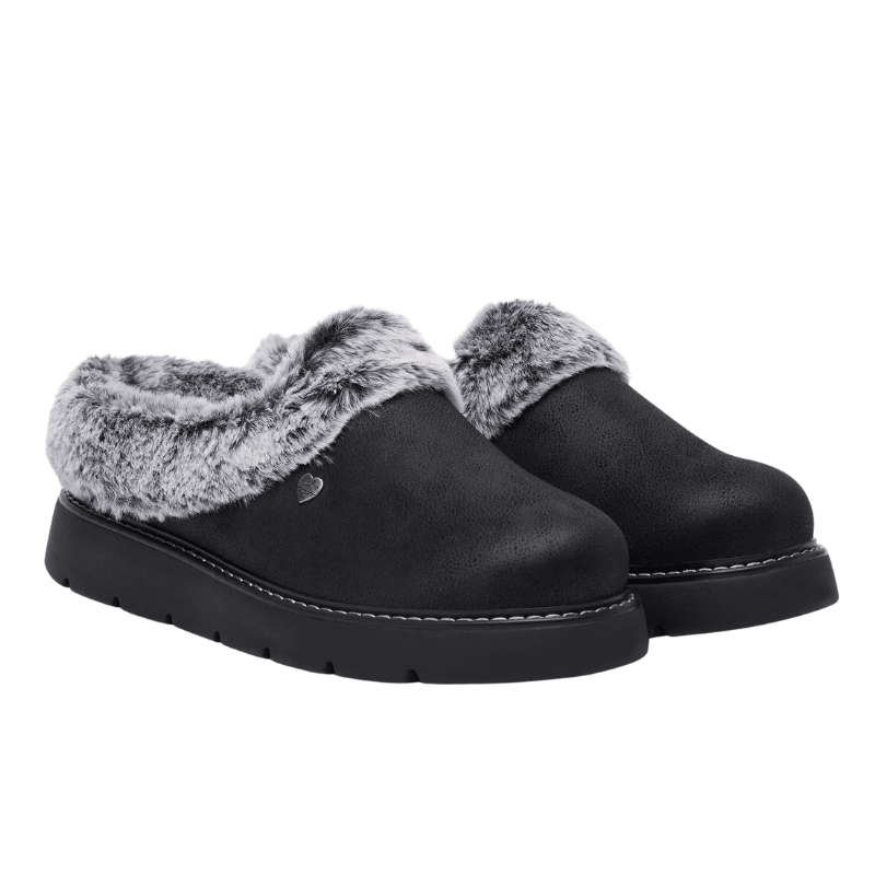 Een paar zwarte Skechers damespantoffels met grijs imitatiebont en suède-look, licht schuin vooraanzicht