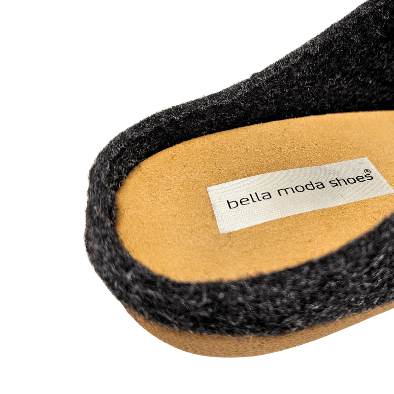 Close-up van de binnenzool van de antracietgrijze wollen pantoffel, met het Bella Moda-merk duidelijk zichtbaar