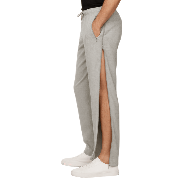 Grijze joggingbroek met open zijrits die het been toont, van de zijkant gezien op een persoon